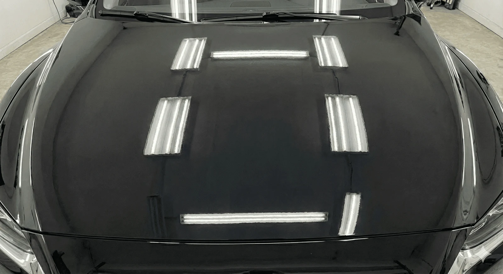 Black hood with a flawless mirror finish after paint correction at Porter’s Detailing