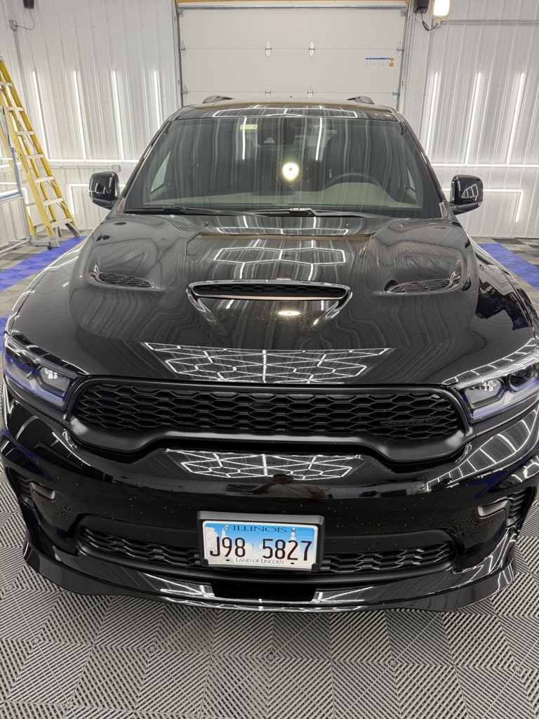 Swirled black Dodge Durango front end under shop lights before paint correction