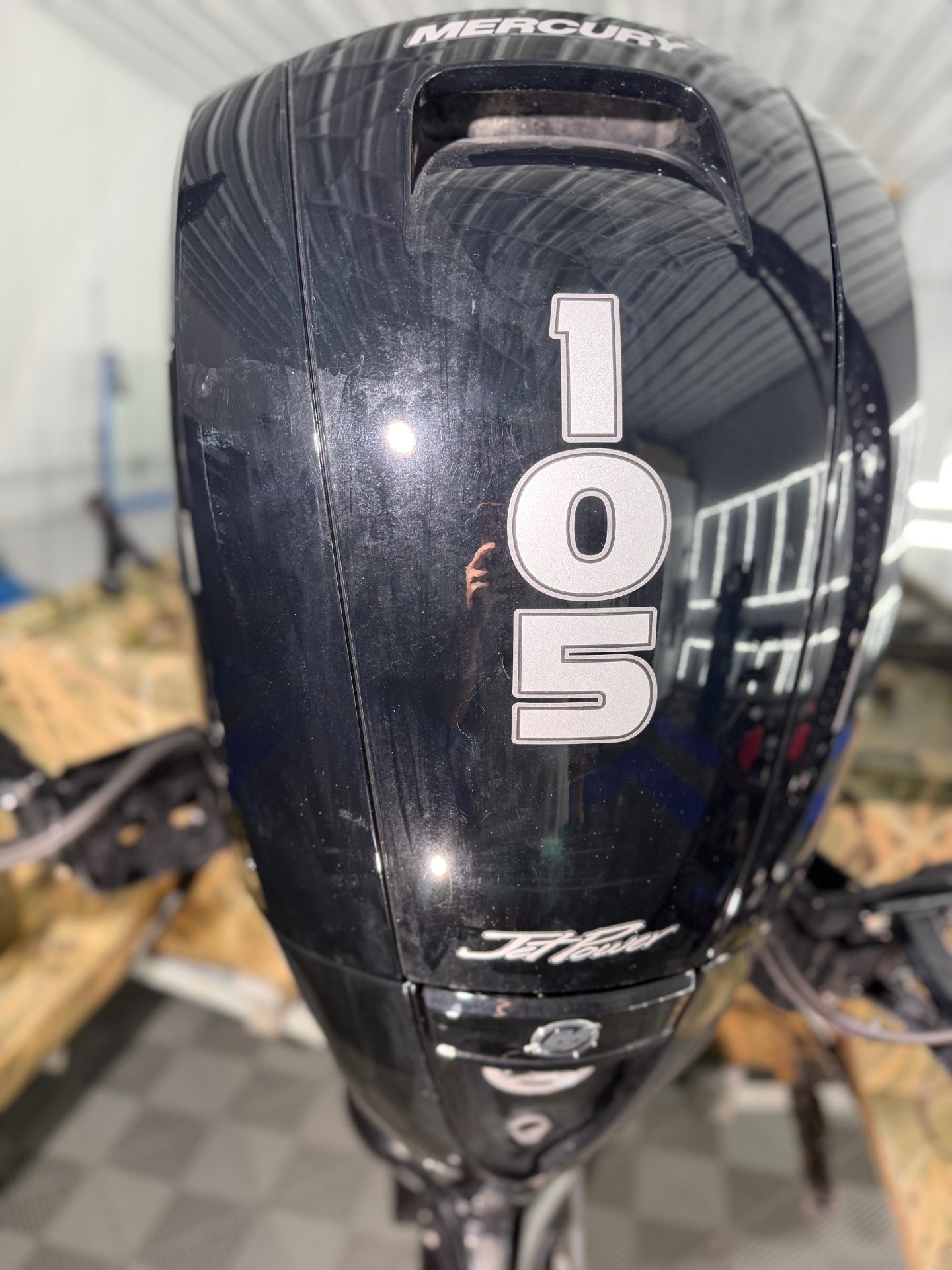 The same Mercury outboard motor cowling swirled and hazy before paint correction