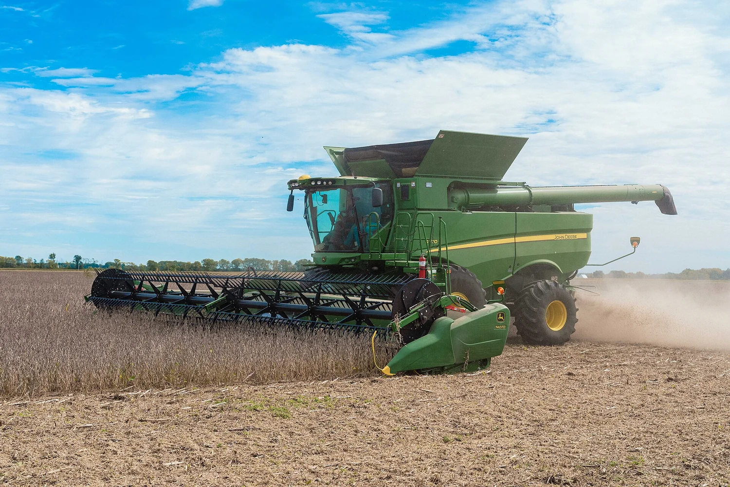 John Deere combine running in a soybean field